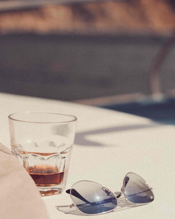 A drink on a table next to some sunglasses